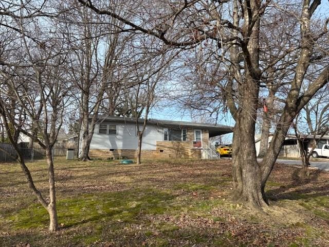 view of front of home with crawl space and fence