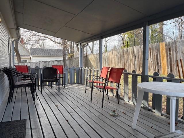 wooden terrace with outdoor dining space and fence