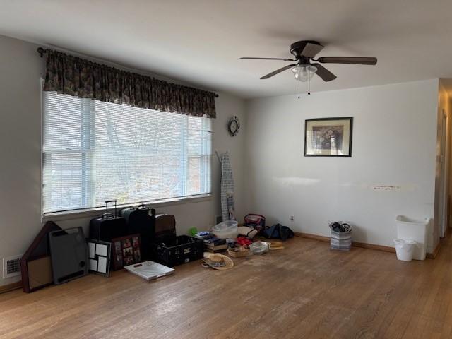 unfurnished dining area featuring light wood-type flooring, baseboards, visible vents, and ceiling fan