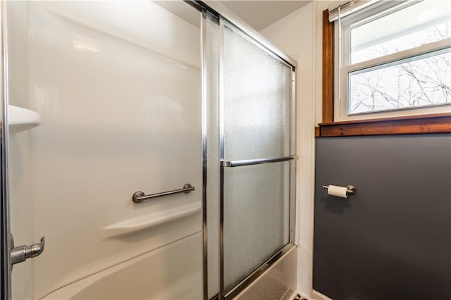 bathroom with a shower with door