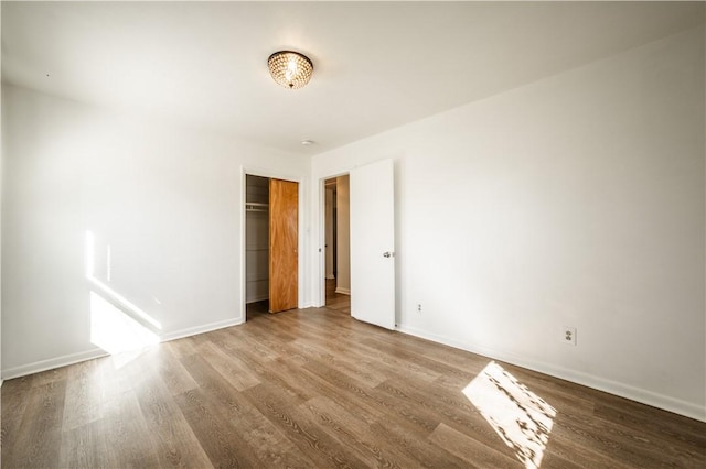 unfurnished room featuring baseboards and wood finished floors