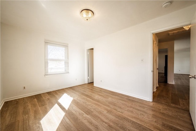 unfurnished room featuring baseboards and wood finished floors