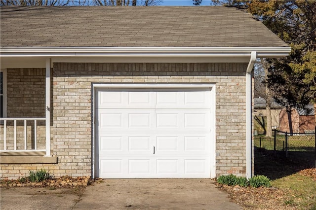 garage with concrete driveway and fence