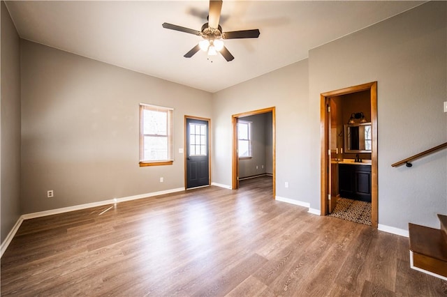 interior space featuring stairs, wood finished floors, a ceiling fan, and baseboards