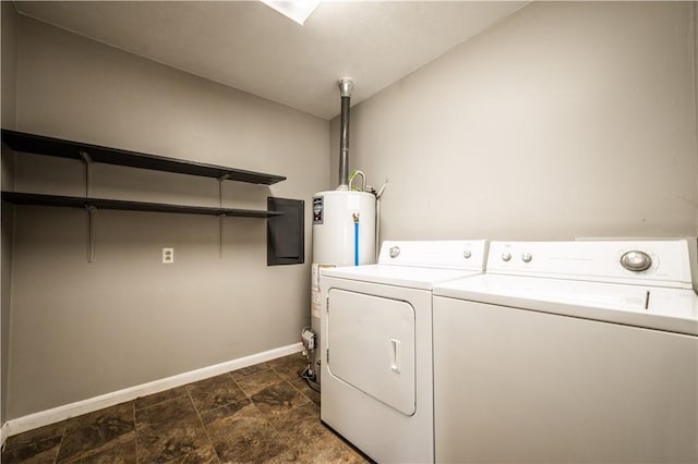 washroom with gas water heater, laundry area, baseboards, stone finish flooring, and washer and clothes dryer