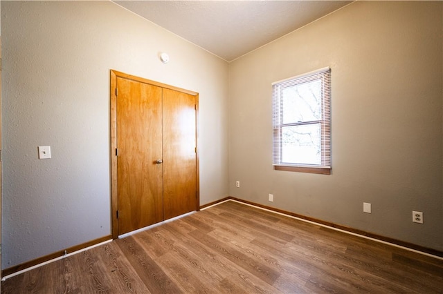 unfurnished bedroom with baseboards and wood finished floors