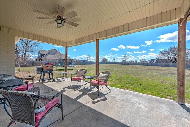 view of patio / terrace with a trampoline, a fenced backyard, and a ceiling fan