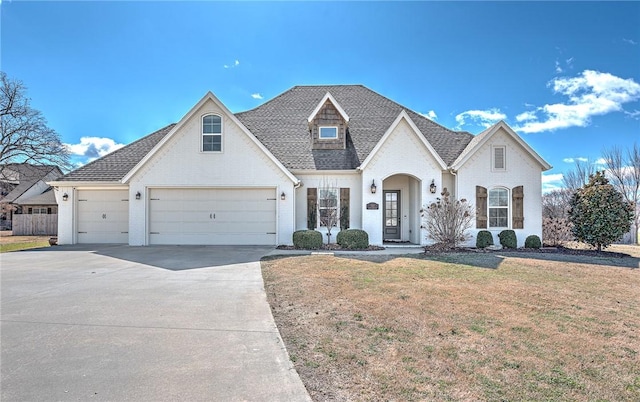 french country home with brick siding, a shingled roof, a front yard, a garage, and driveway