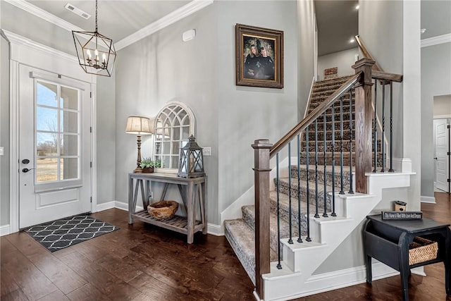 entryway with hardwood / wood-style flooring, visible vents, baseboards, stairs, and ornamental molding