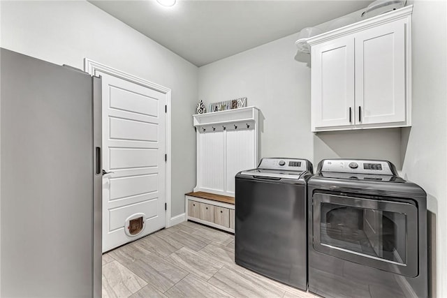 laundry room with cabinet space, baseboards, and washing machine and clothes dryer