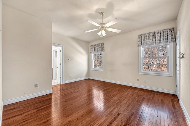 empty room featuring a ceiling fan, wood-type flooring, and baseboards