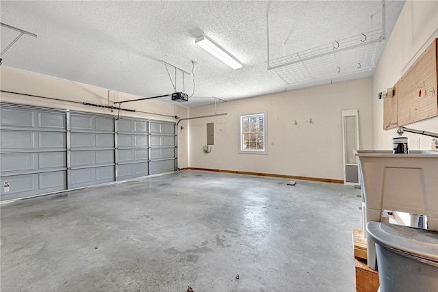 garage featuring a garage door opener, electric panel, and baseboards