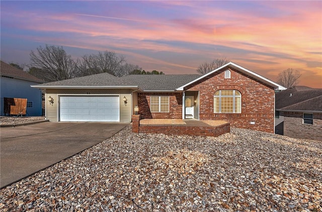 ranch-style home featuring a garage, brick siding, driveway, and a shingled roof