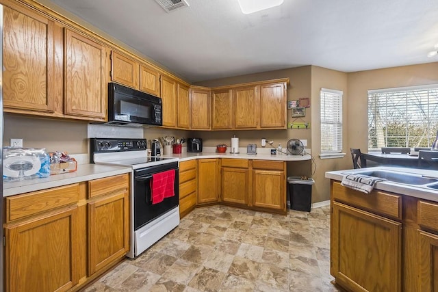 kitchen featuring visible vents, electric stove, brown cabinets, light countertops, and black microwave