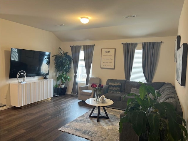 living room with vaulted ceiling, dark wood-style flooring, and visible vents