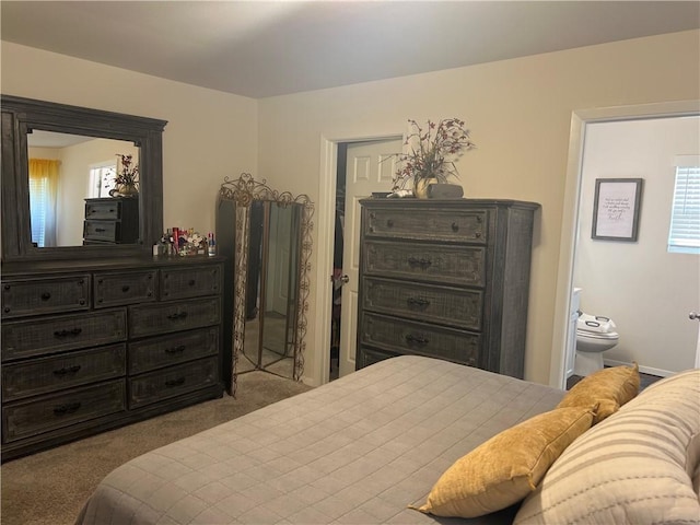 carpeted bedroom featuring ensuite bath