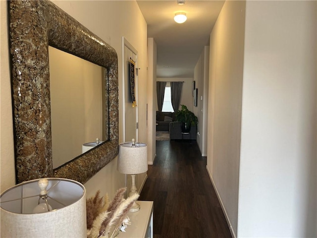 hallway featuring dark wood-style floors and baseboards