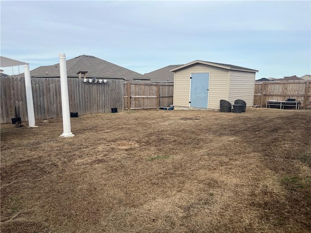 view of yard with a storage unit, an outdoor structure, and a fenced backyard