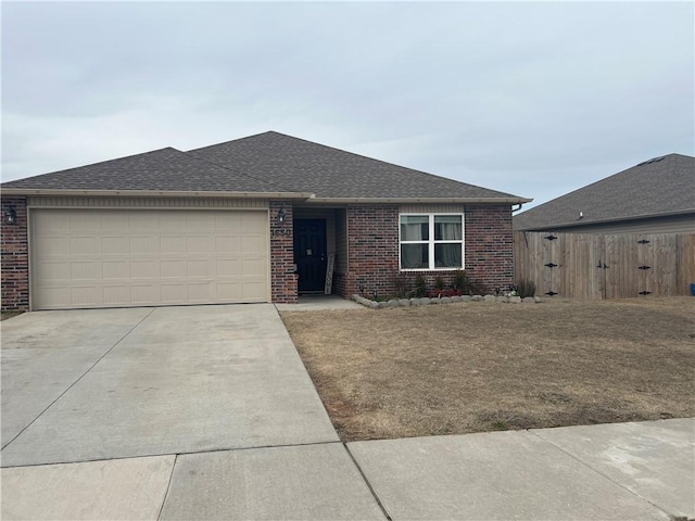 view of front of house with concrete driveway, roof with shingles, an attached garage, fence, and brick siding