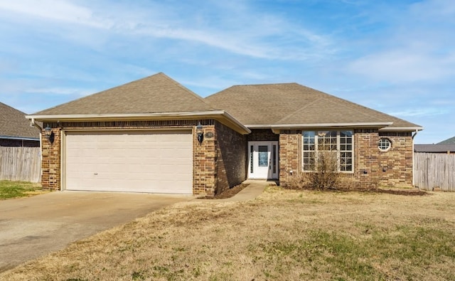 single story home featuring brick siding, a shingled roof, fence, a garage, and driveway