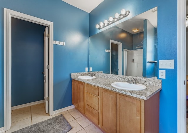 full bathroom with a sink, a shower with door, double vanity, and tile patterned floors