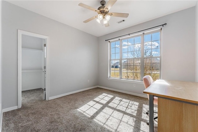 unfurnished office featuring visible vents, baseboards, a ceiling fan, and carpet flooring