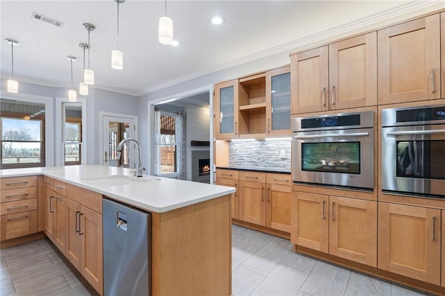 kitchen featuring a healthy amount of sunlight, backsplash, stainless steel appliances, and a sink