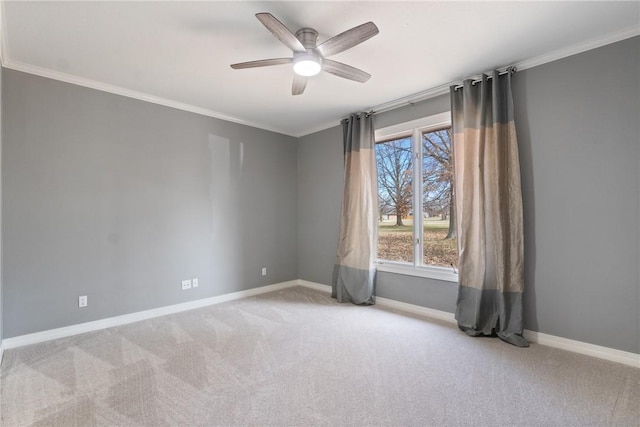 carpeted spare room featuring baseboards, ornamental molding, and ceiling fan