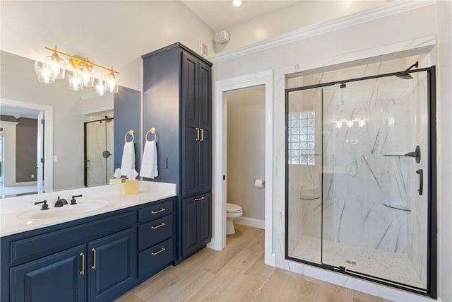 bathroom featuring vanity, wood finished floors, a marble finish shower, and toilet