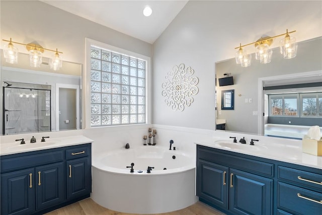 full bath featuring two vanities, plenty of natural light, and a sink