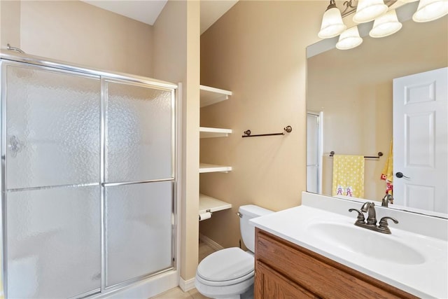 bathroom featuring vanity, a shower stall, and toilet