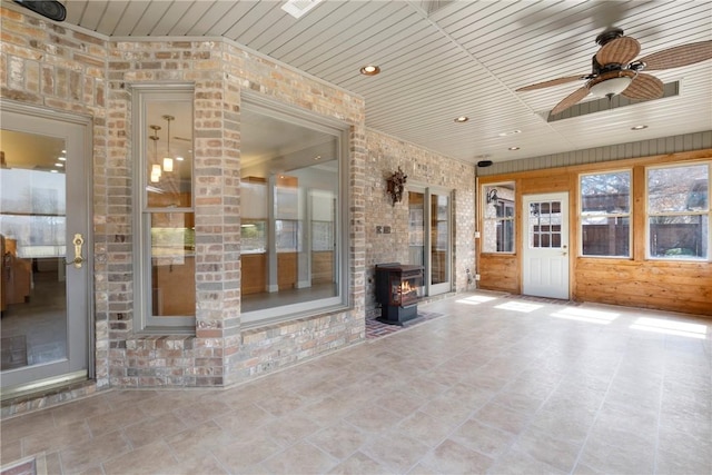 interior space featuring a wood stove, wood ceiling, ceiling fan, and recessed lighting