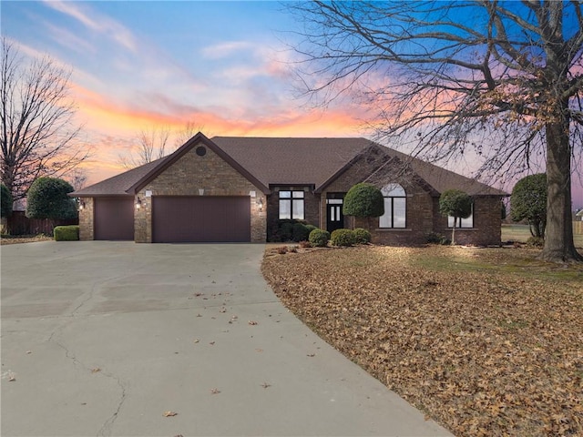 view of front of home with concrete driveway, brick siding, and an attached garage