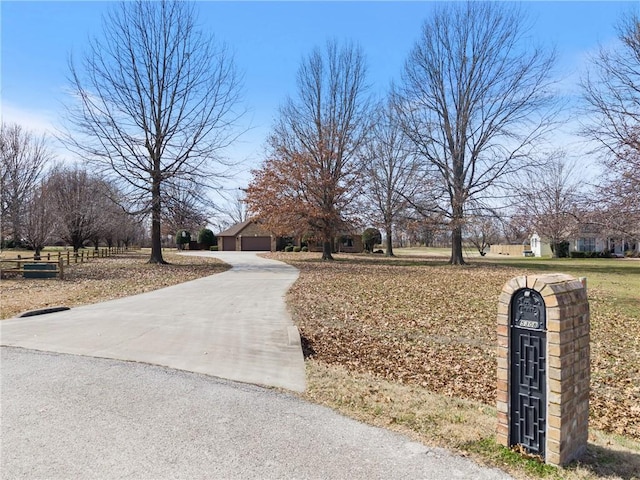 view of road featuring concrete driveway