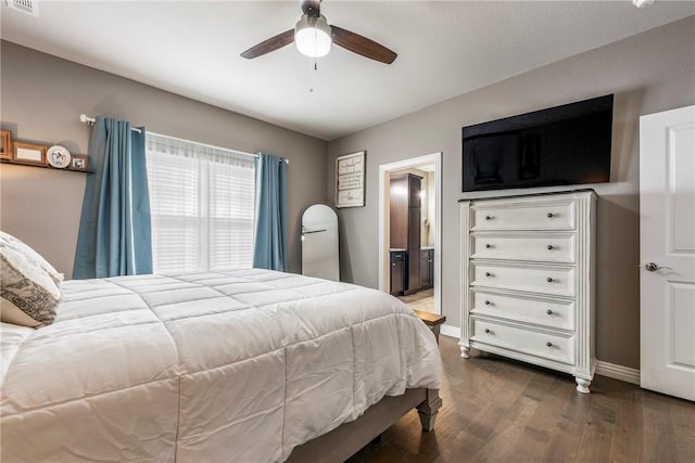 bedroom featuring ensuite bathroom, wood finished floors, visible vents, and baseboards