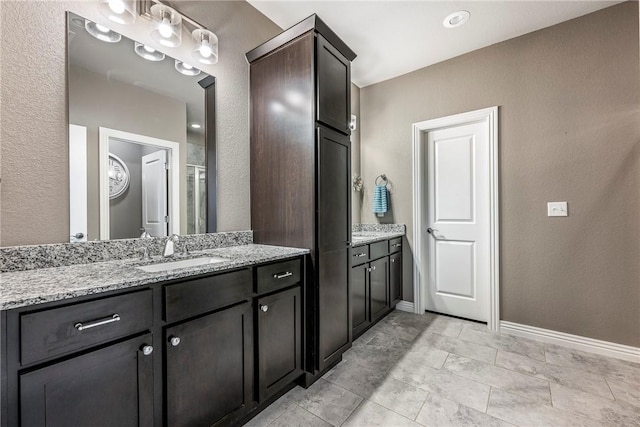 full bath featuring vanity and baseboards