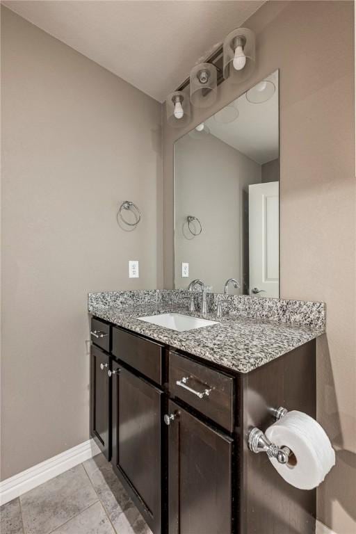 bathroom with vanity, baseboards, and tile patterned floors