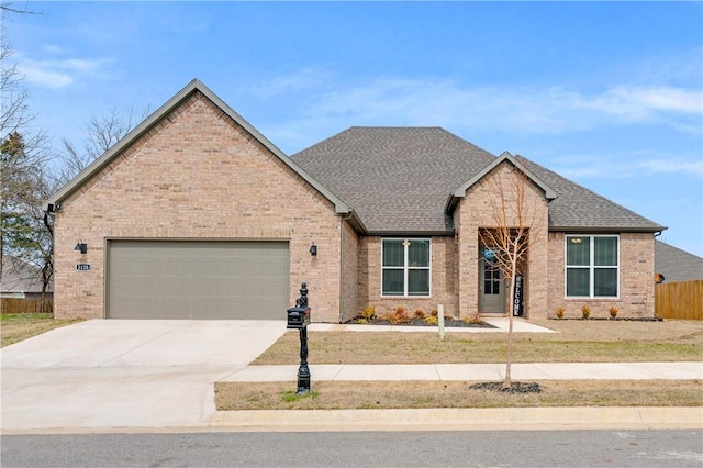 view of front of home featuring brick siding, a shingled roof, an attached garage, fence, and driveway