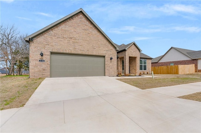 ranch-style home with driveway, brick siding, an attached garage, and fence