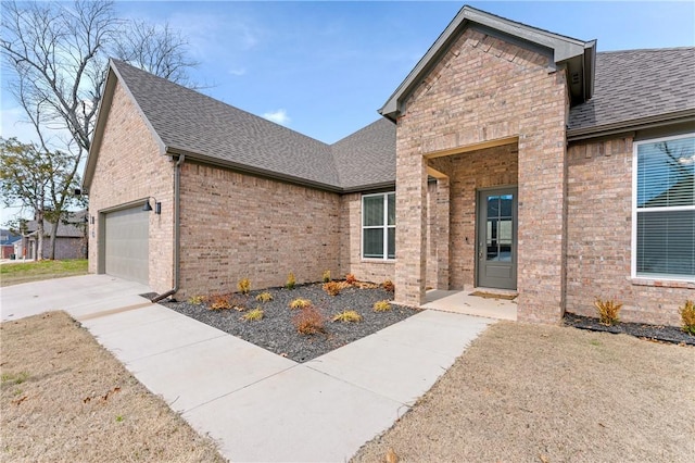 view of front of property featuring concrete driveway, brick siding, roof with shingles, and an attached garage