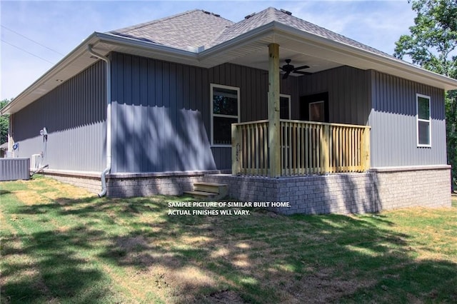 rear view of house with ceiling fan, roof with shingles, a porch, and a yard