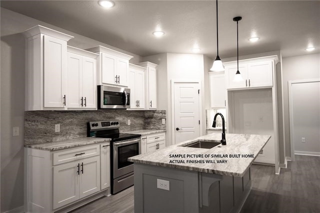 kitchen with stainless steel appliances, white cabinetry, a sink, and tasteful backsplash