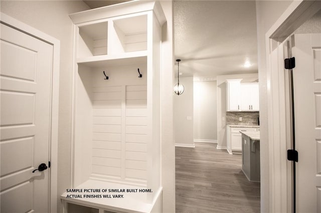 mudroom with wood finished floors and baseboards