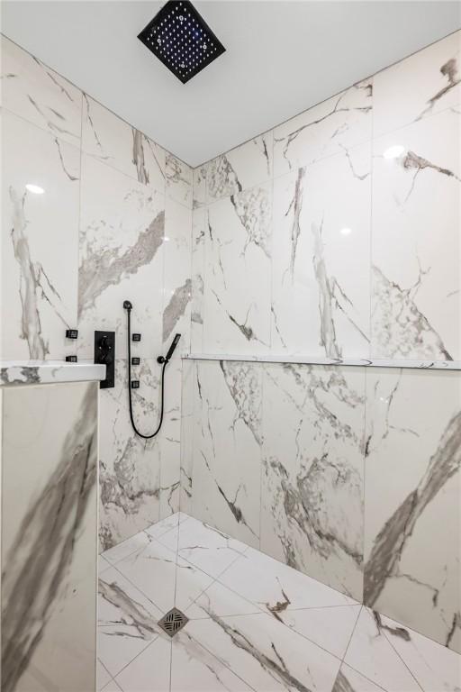 bathroom featuring a marble finish shower