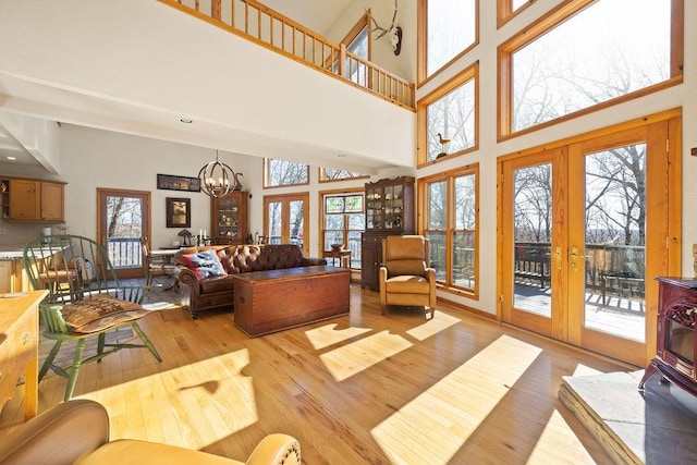 living room featuring light wood-style floors, french doors, and an inviting chandelier