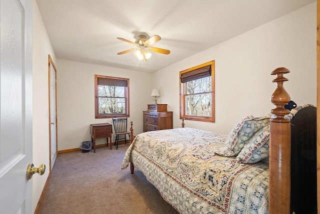 carpeted bedroom featuring a ceiling fan, multiple windows, and baseboards