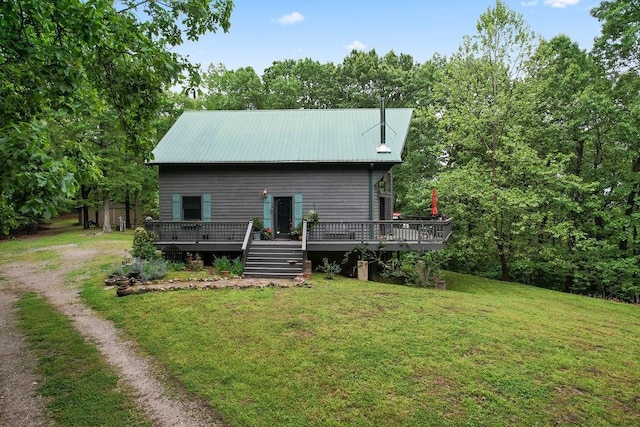 back of property with a yard, metal roof, driveway, and a deck