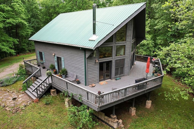 back of house featuring metal roof and a wooden deck