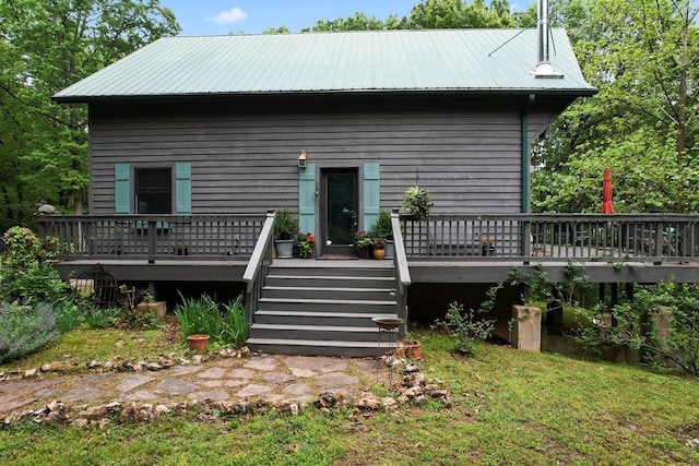 rear view of property featuring metal roof and a deck