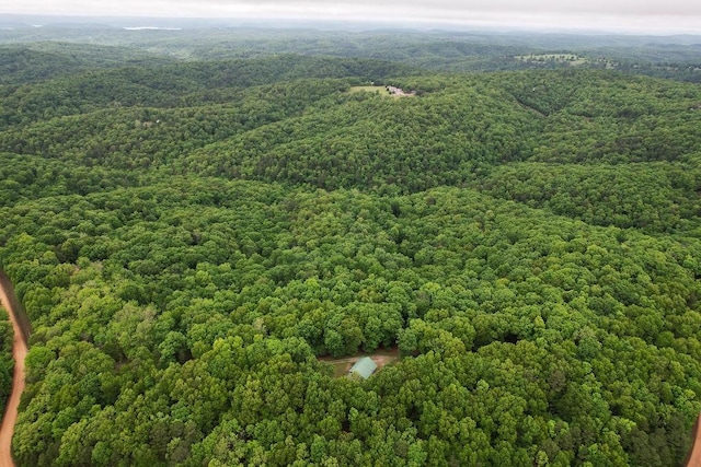 drone / aerial view featuring a wooded view